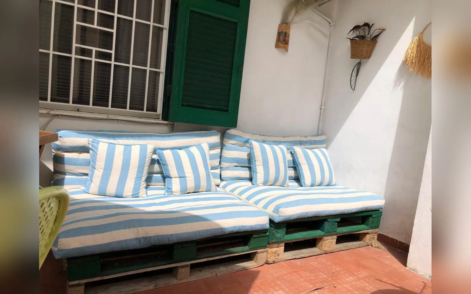 Terrazza sul giardino, divani con cuscini a righe sulla terrazza